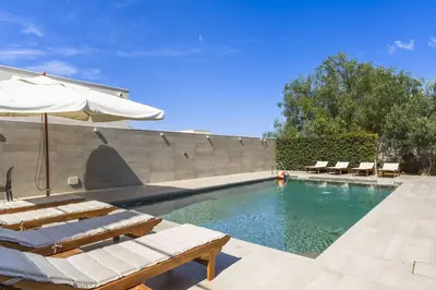 a swimming pool with lounge chairs and an umbrella at Villa Bizzarria in Castellammare del Golfo