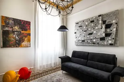 a living room with a black couch and a window at Libertà 78 - Art Suite & Spa in Palermo