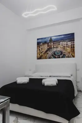 a bedroom with a bed with a painting on the wall at Mariblu Palermo in Palermo