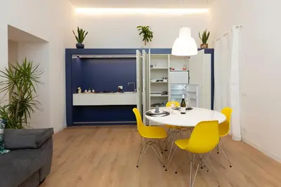 a dining room with a white table and yellow chairs at Massim'home in Palermo