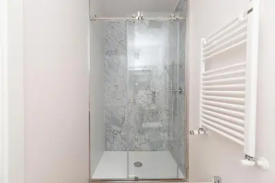 a shower with a glass door in a bathroom at Massim'home in Palermo