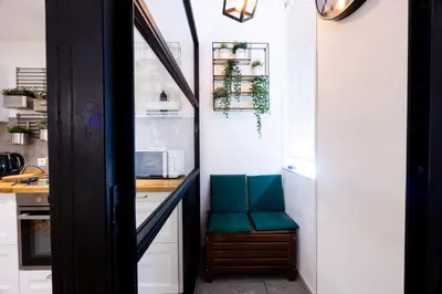 a kitchen with a counter with green chairs in it at Oasi Libertà in Palermo