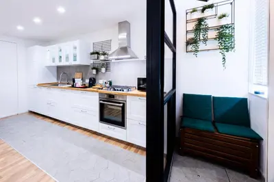 a kitchen with white cabinets and green accents at Oasi Libertà in Palermo