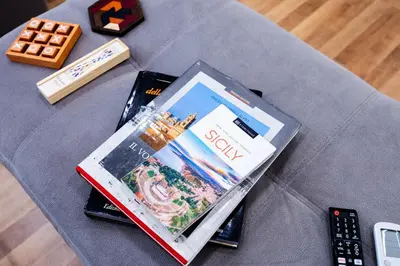 a table topped with a book and a remote control at Oasi Libertà in Palermo