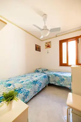 a bedroom with two beds and a window at Calasole House: Mare a 2 Passi in San Vito lo Capo