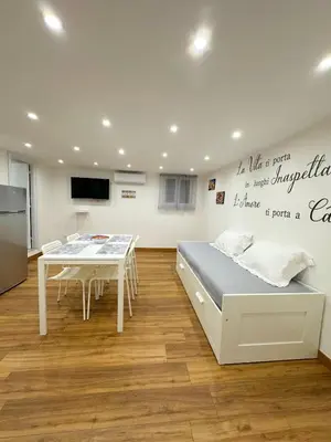 a room with a bed and a table and a tv at M&F Home in Palermo