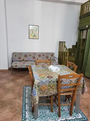 a dining room with a table and chairs and a couch at Casa Vacanze Sole in Castellammare del Golfo