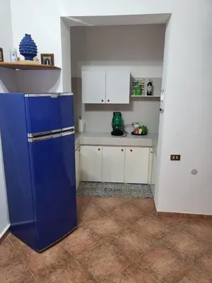 a kitchen with a blue refrigerator and white cabinets at Casa Vacanze Sole in Castellammare del Golfo