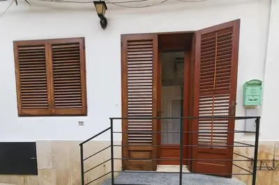 two wooden doors on a building with a railing at Casa Vacanze Sole in Castellammare del Golfo