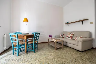 a living room with a couch and a table and chairs at Buffa Apartaments by DomuSicily in Mondello
