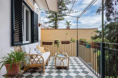 a balcony with a couch and chairs on a porch at Buffa Apartaments by DomuSicily in Mondello