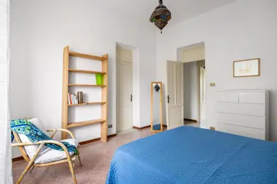 a bedroom with a blue bed and a chair at Buffa Apartaments by DomuSicily in Mondello