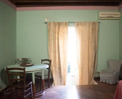 a table and chairs in a room with a window at casetta mon amour in Palermo