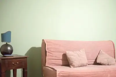 a pink couch with two pillows on a table at casetta mon amour in Palermo