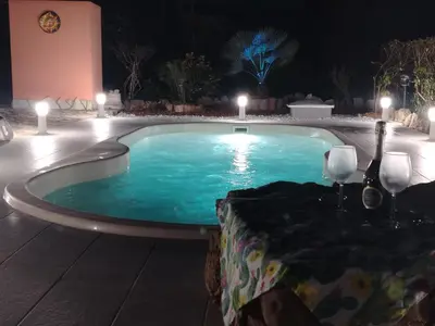 a swimming pool at night with candles and lights at Villa Nuccia Oasi di relax con piscina in Castellammare del Golfo