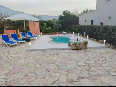 a swimming pool with chairs and a table and an umbrella at Villa Nuccia Oasi di relax con piscina in Castellammare del Golfo