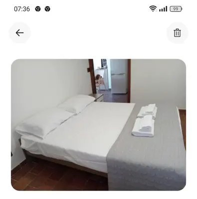 a bedroom with a large bed with white sheets at Casa giambona in Capaci