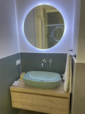 a bathroom with a sink with a round mirror at Central Empire in Palermo