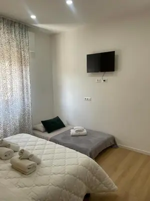 a bedroom with two beds and a flat screen tv at Central Empire in Palermo