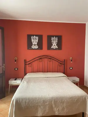 a bedroom with a red wall with a bed at A Casa di Amy 2.0 in Macari