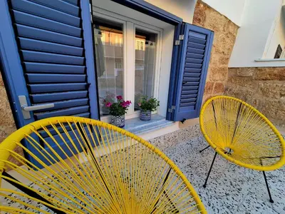 two yellow chairs sitting in front of a door at Azzurra Home in Terrasini