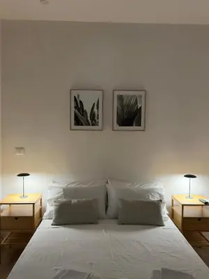a bedroom with a white bed with two end tables at Aloha in Palermo