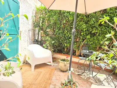 a patio with a white chair and an umbrella at CasaRò (delizioso alloggio a Mondello) in Palermo