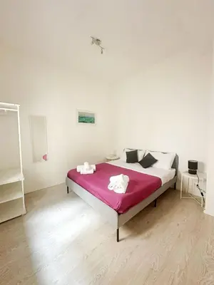 a bedroom with a bed with a pink blanket at Casa Politeama Florio - Palermo centro in Palermo