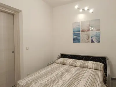 a bedroom with a bed and a picture on the wall at La Casetta di Nino in Castellammare del Golfo