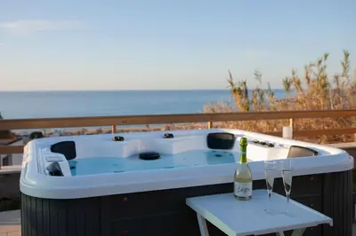 a hot tub with a bottle of wine on a table at Villa Laura in Balestrate