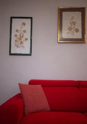 a red couch in a living room with two pictures at Villa Laura in Balestrate