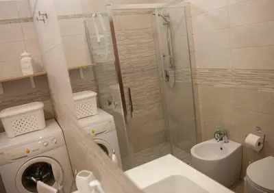 a bathroom with a shower and a washing machine at Villa Laura in Balestrate