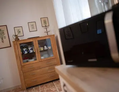 a living room with a wooden cabinet and a television at Villa Laura in Balestrate