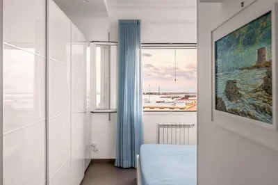 a white room with a window and a painting at FronteMare in Palermo