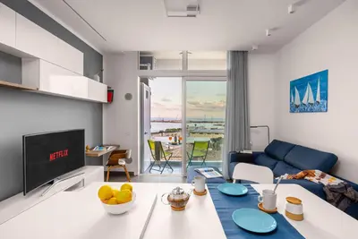a living room with a blue couch and a table at FronteMare in Palermo