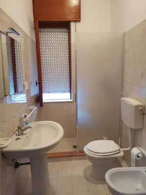 a bathroom with a sink and a toilet and a window at La Vie Est Belle in Balestrate