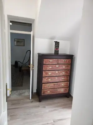 a bedroom with a dresser and a hallway with a chair at Casa Giannina in Palermo
