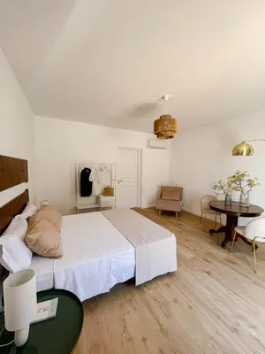 a bedroom with a large bed and a table at Castellano suites in Castellammare del Golfo