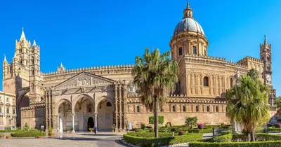 a large building with a cathedral and palm trees at NARBONE 42 in Palermo