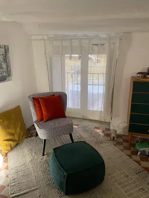 a living room with a chair and a window at Studio 29 in Palermo