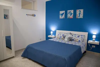 a blue bedroom with a bed with blue sheets and pillows at L'ancora casa vacanze in Palermo