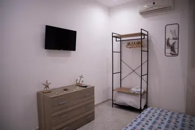a bedroom with a dresser and a tv on a wall at L'ancora casa vacanze in Palermo