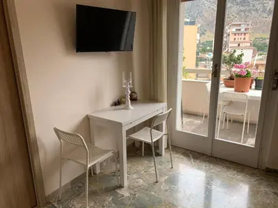 a room with a white table and chairs and a television at A Casa di Giovi in Palermo