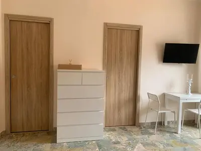 a room with a dresser and a desk and a table at A Casa di Giovi in Palermo