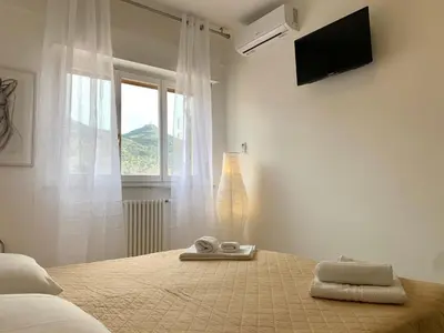 a white bedroom with a bed and a window at A Casa di Giovi in Palermo