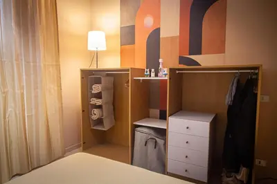 a bedroom with a bed and a dresser and a closet at vivà house in Palermo