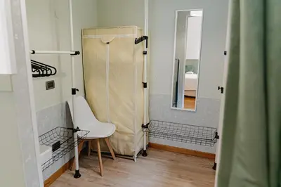 a bathroom with a shower and a chair and a mirror at SANT'ELIGIO APARTMENTS & ROOMS in Palermo