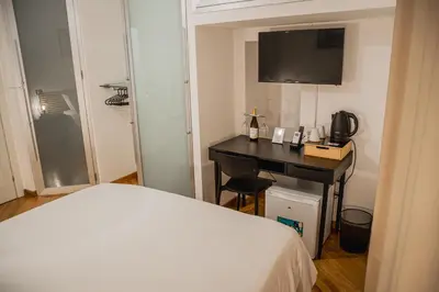 a bedroom with a bed and a desk with a television at SANT'ELIGIO APARTMENTS & ROOMS in Palermo