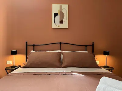 a bedroom with a large bed with two lamps at M'AMA apartment 1 in Ficarazzi