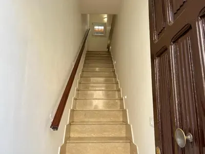 a staircase in a hallway with a wooden door at M'AMA apartment 2 in Ficarazzi